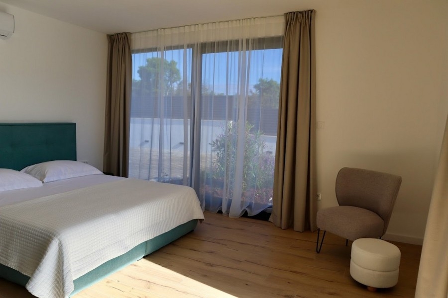 Chambre avec lit double et porte-fenêtre donnant sur le jardin