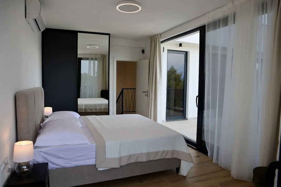 Chambre avec armoire à miroir et accès au balcon