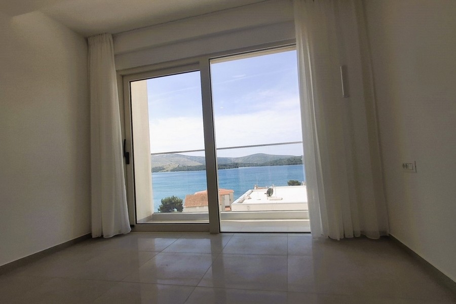 Pièce vide avec porte coulissante et vue sur la baie et les collines