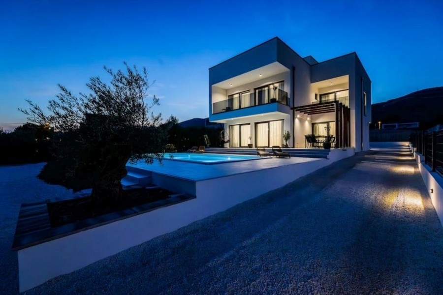 Villa moderne de nuit avec piscine éclairée