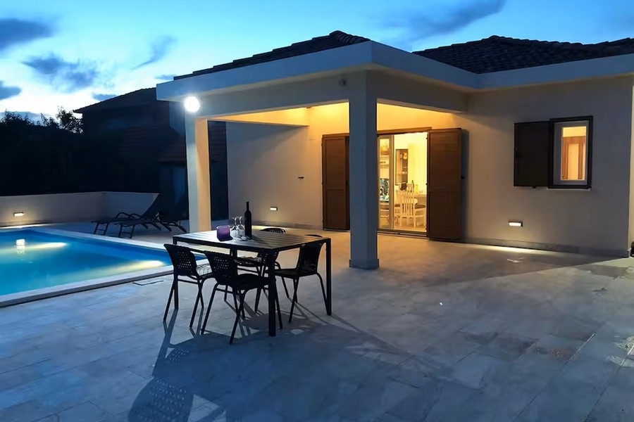 Bungalow le soir avec piscine et terrasse couverte