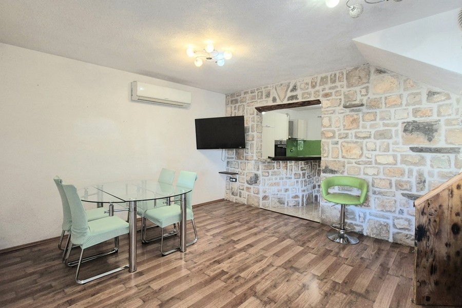 Séjour et coin repas avec mur en pierre