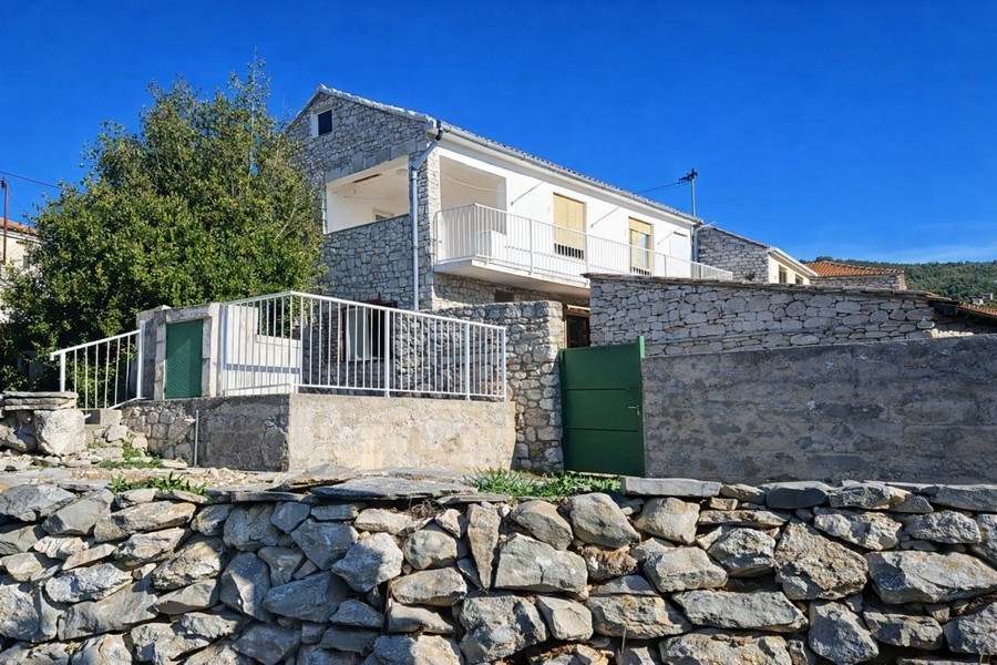 Vue extérieure de la maison en pierre avec mur en pierre
