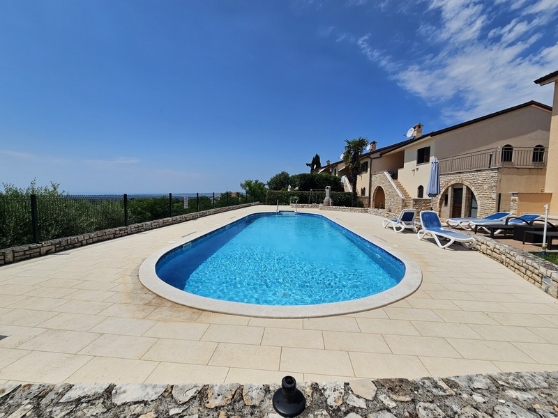 Espace piscine carrelé avec terrasse et résidence