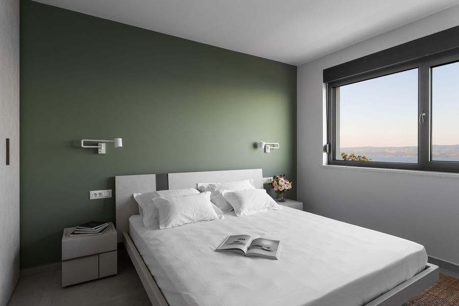 Chambre lumineuse avec grande fenêtre et vue mer