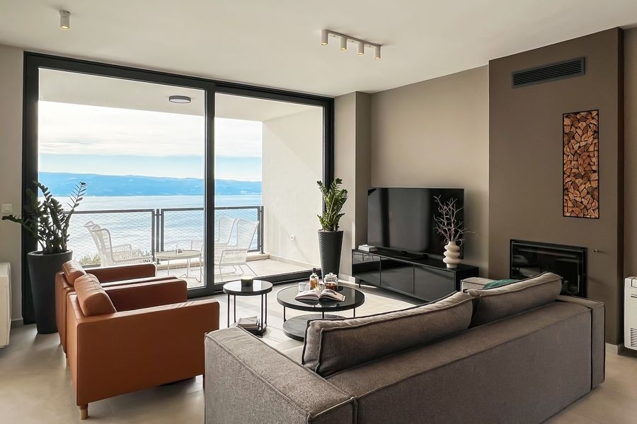 Salon avec cheminée et fenêtre panoramique donnant sur la mer