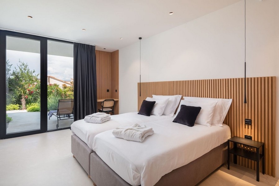 Chambre avec mur en bois et accès au jardin