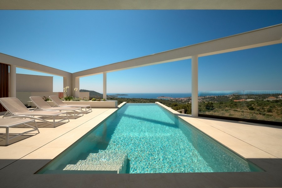Solarium avec piscine à débordement et vue panoramique sur la mer