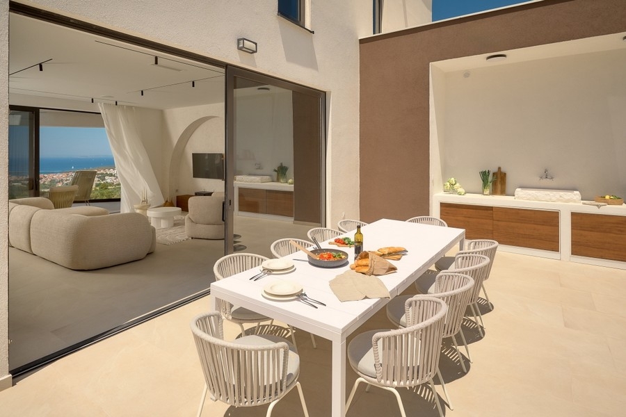 Séjour et coin repas avec table dressée et vue mer