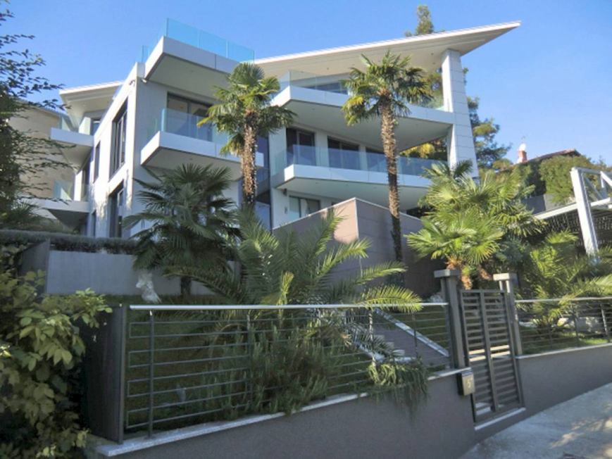 Villa claire avec palmiers et clôture métallique à l'accès