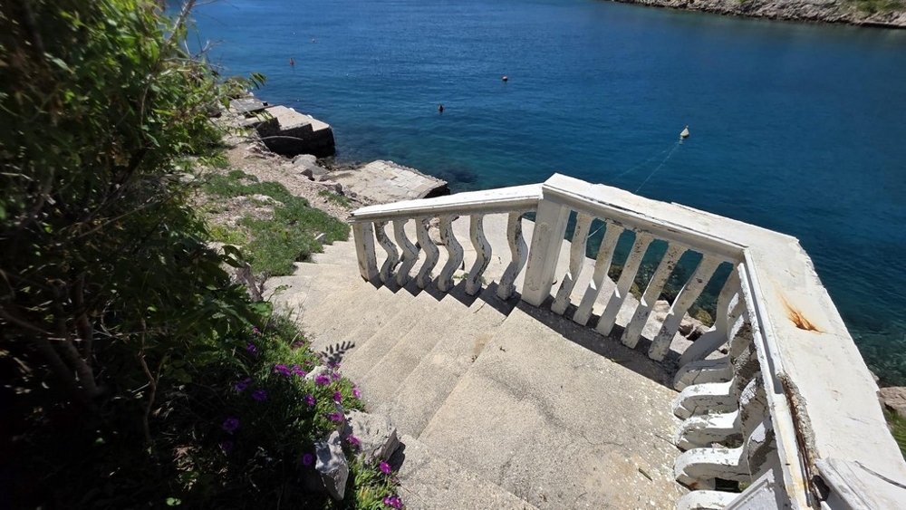 Escalier en pierre avec balustrade menant à la mer