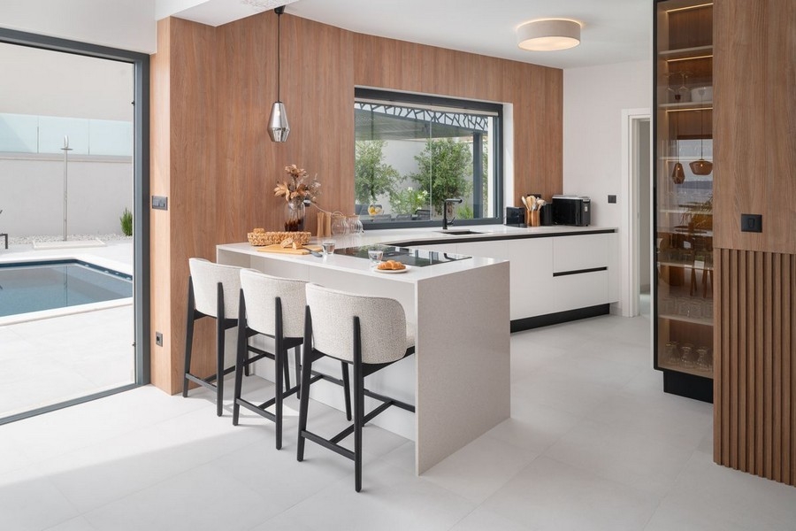 Cuisine moderne avec îlot et vue sur la piscine