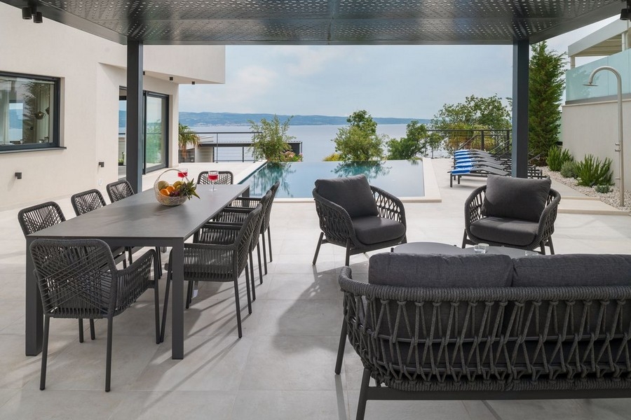 Terrasse couverte avec coin repas et vue mer