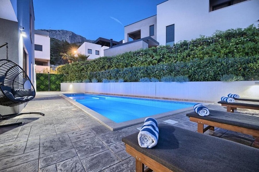 Piscine chauffée avec fauteuil suspendu et vue sur les montagnes en Croatie