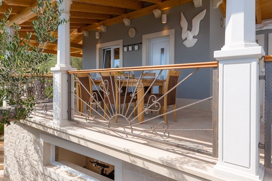 Terrasse couverte avec garde-corps près de la maison