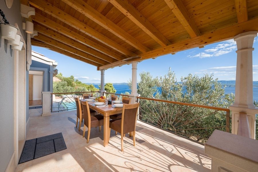 Terrasse couverte avec table dressée et vue mer