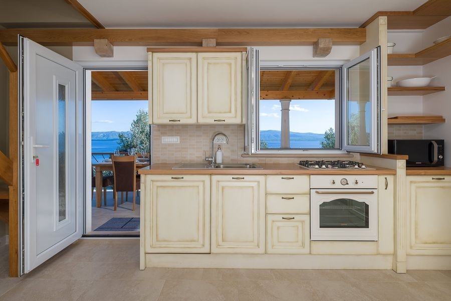 Cuisine claire avec fenêtre donnant sur la mer