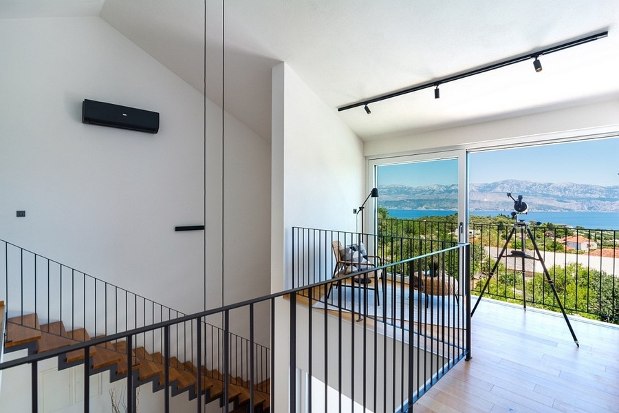 Cage d'escalier avec accès au balcon et vue mer