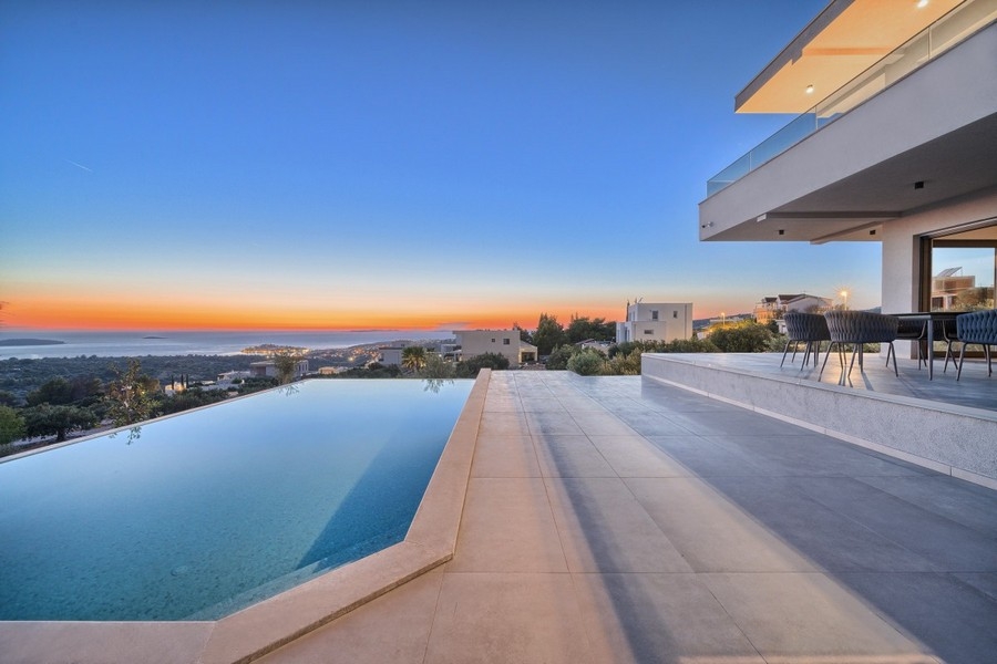Piscine à débordement avec vue mer au coucher du soleil
