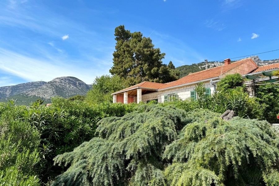 Jardin méditerranéen avec maisons en pierre et vue sur les montagnes
