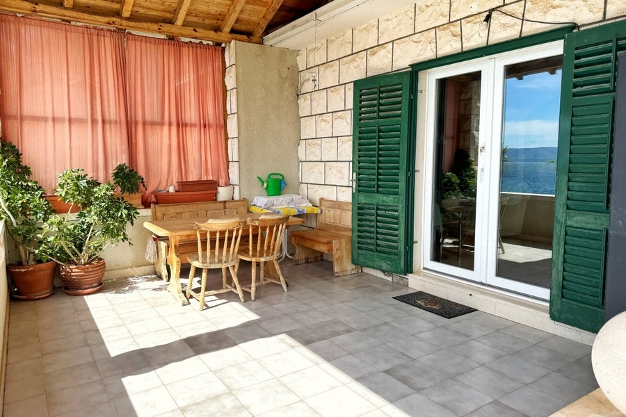 Terrasse couverte avec coin salon et vue mer