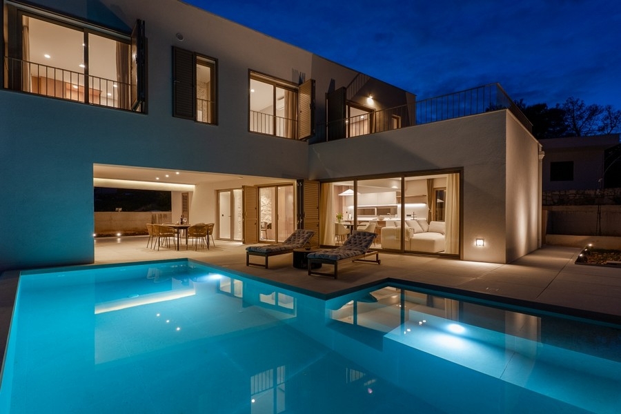 Villa éclairée avec piscine au crépuscule