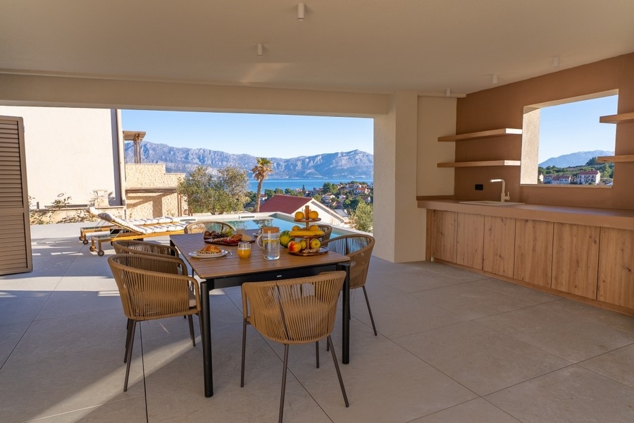 Terrasse couverte avec coin repas et cuisine extérieure