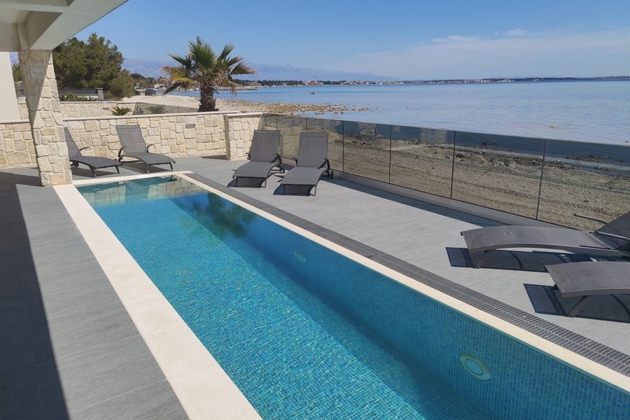 Piscine avec bains de soleil directement au bord de la mer sur l'île de Vir