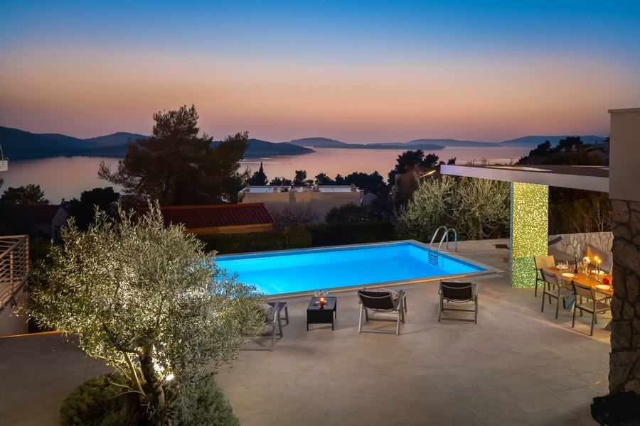 Piscine avec cuisine d'été et vue mer le soir