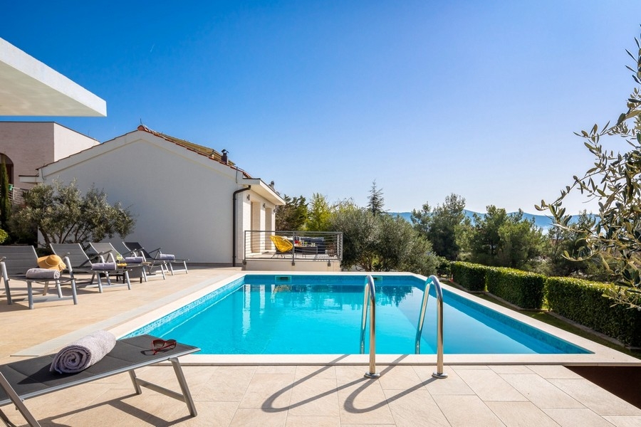 Piscine avec bains de soleil et vue mer
