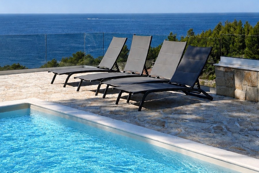 Piscine avec bains de soleil et vue mer