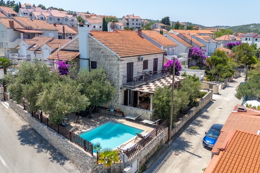 Vue sur la maison en pierre et la piscine à Sutivan