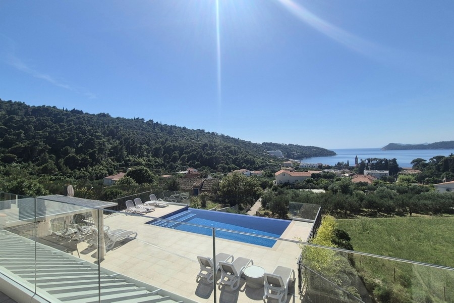 Terrasse de la piscine avec bains de soleil et vue mer