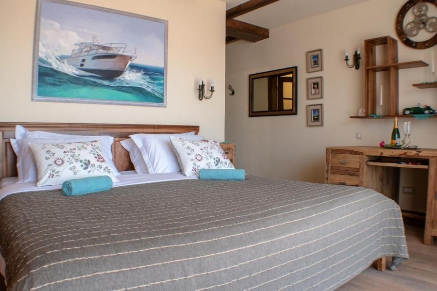 Chambre avec lit double et tableau marin