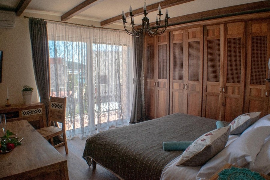 Chambre avec armoires en bois et accès à la terrasse