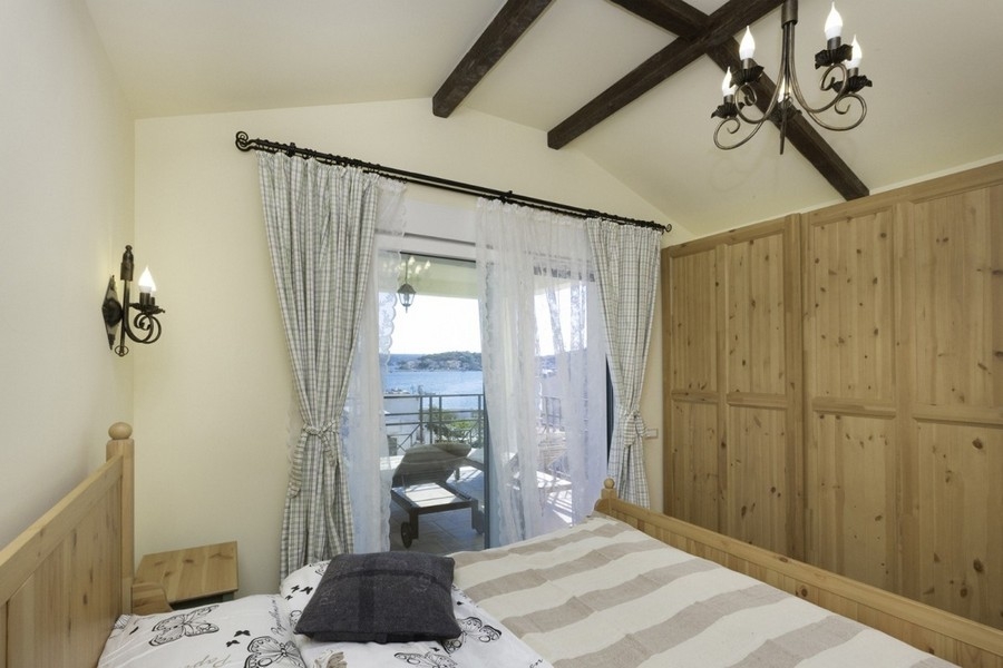 Chambre avec accès au balcon et plafond en bois