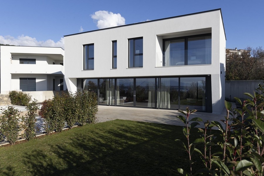 Jardin avec pelouse et façade vitrée