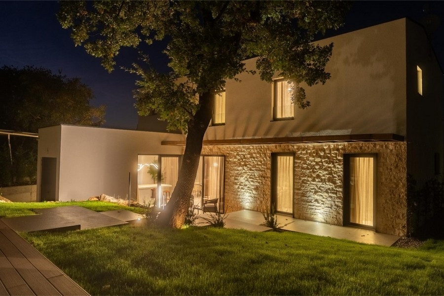 Villa éclairée à façade en pierre la nuit