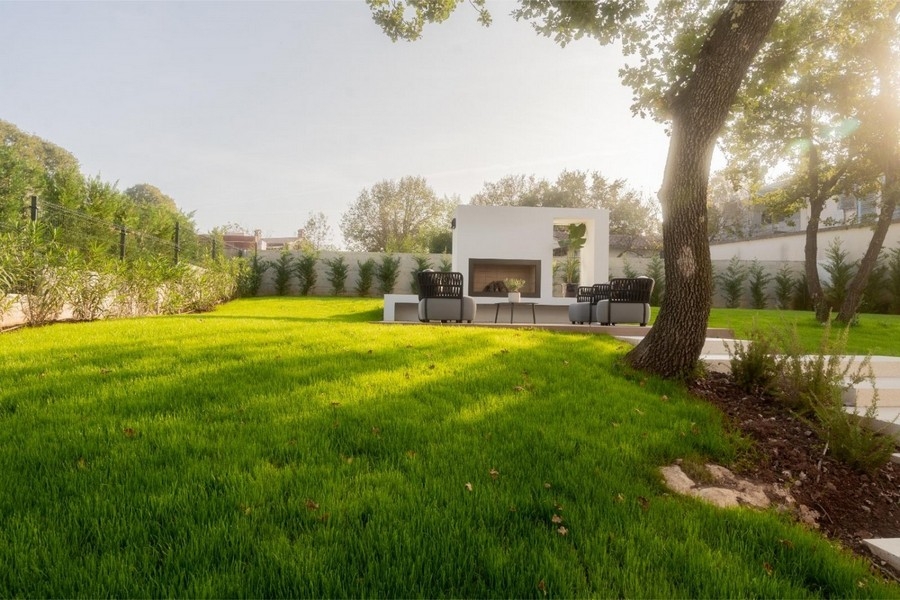 Jardin avec cheminée d'extérieur et fauteuils lounge