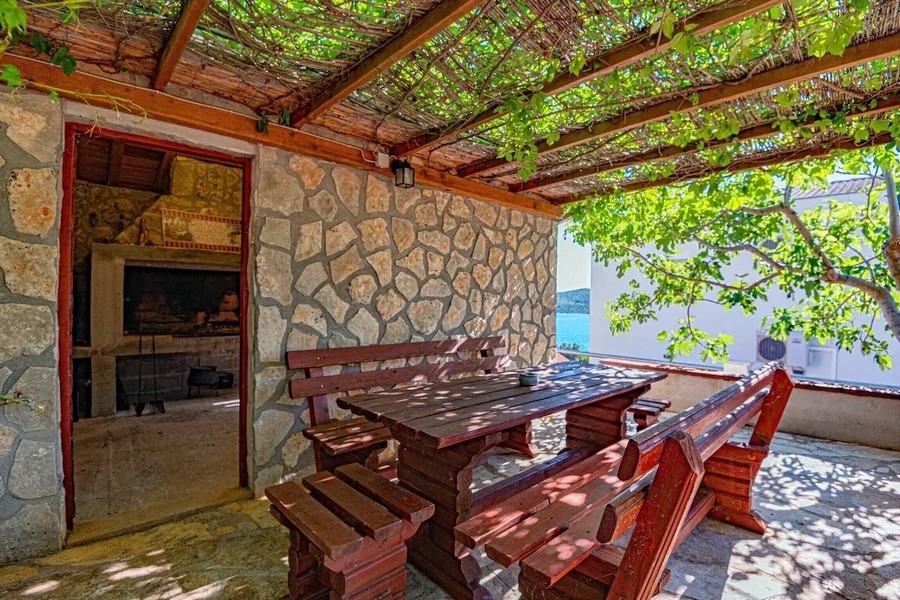 Cuisine d'été couverte avec grill et table en bois