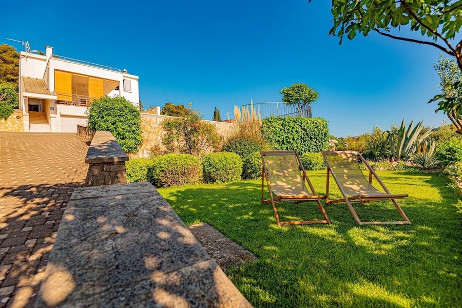 Jardin avec pelouse et chaises longues