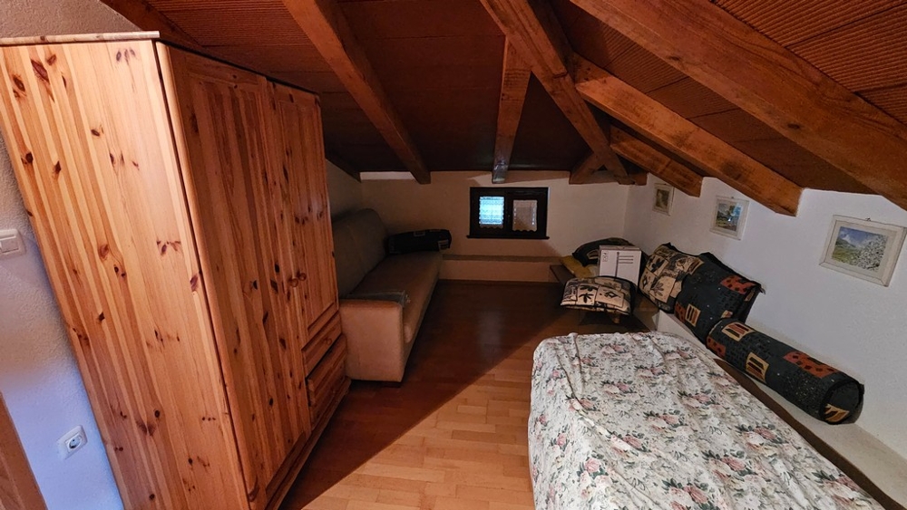 Pièce sous les toits avec armoire et canapé-lit
