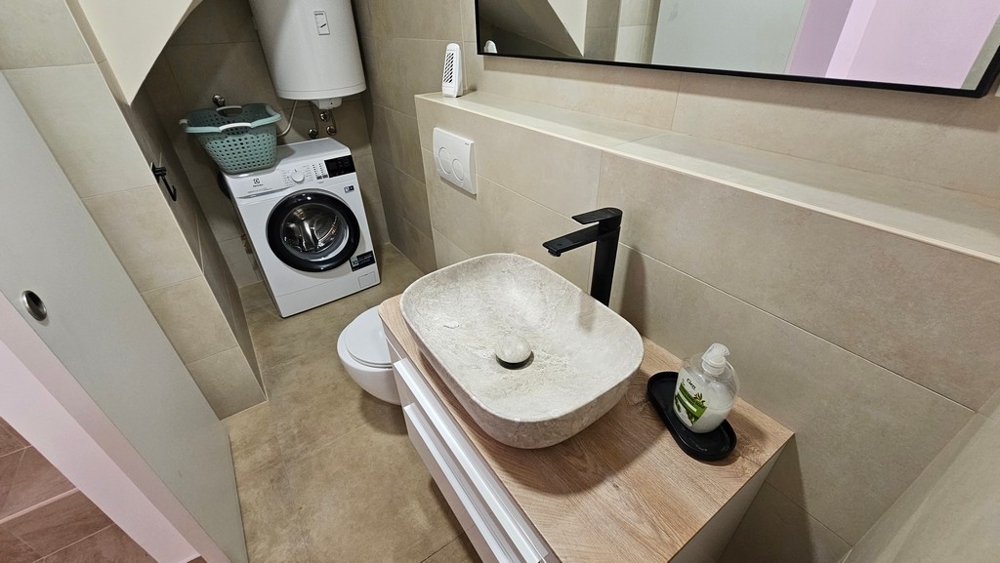 Salle de bains avec lavabo et lave-linge