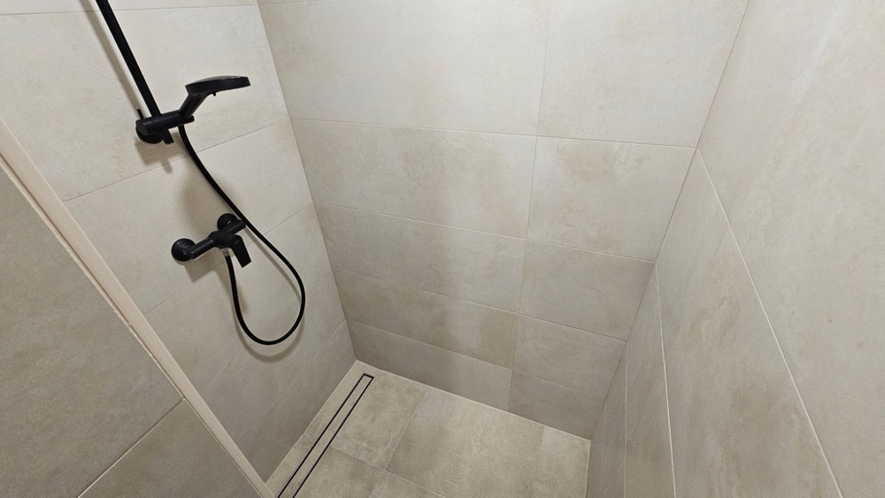 Douche dans la salle de bains de la maison en bande