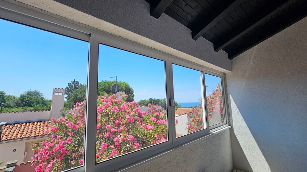 Vue mer par-dessus le jardin à travers la fenêtre