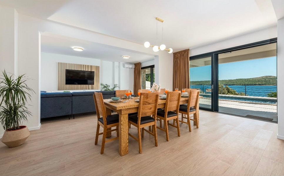 Pièce de vie avec grande table et vue mer