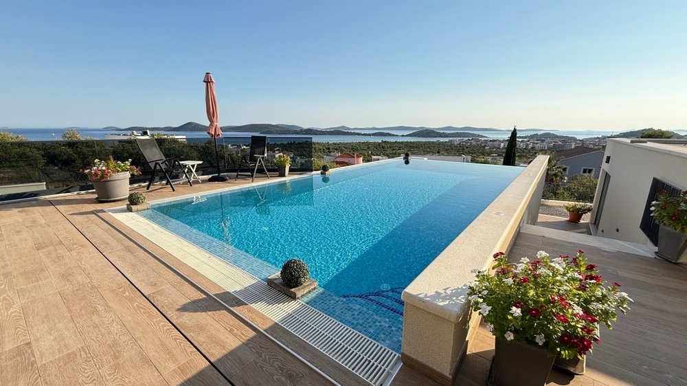 Piscine chauffée avec terrasse solarium et vue mer