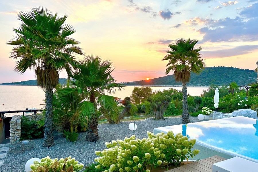Coucher de soleil sur la mer avec palmiers et piscine
