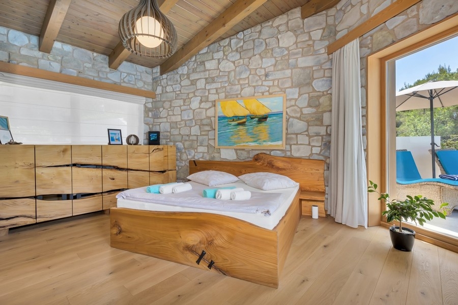 Chambre avec mur en pierre et accès à la piscine