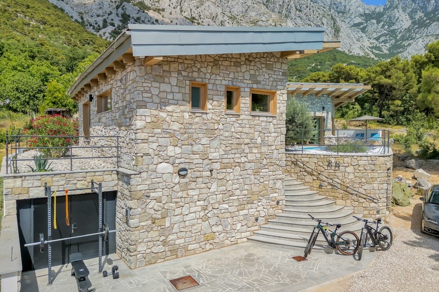 Façade en pierre avec garage et escalier extérieur